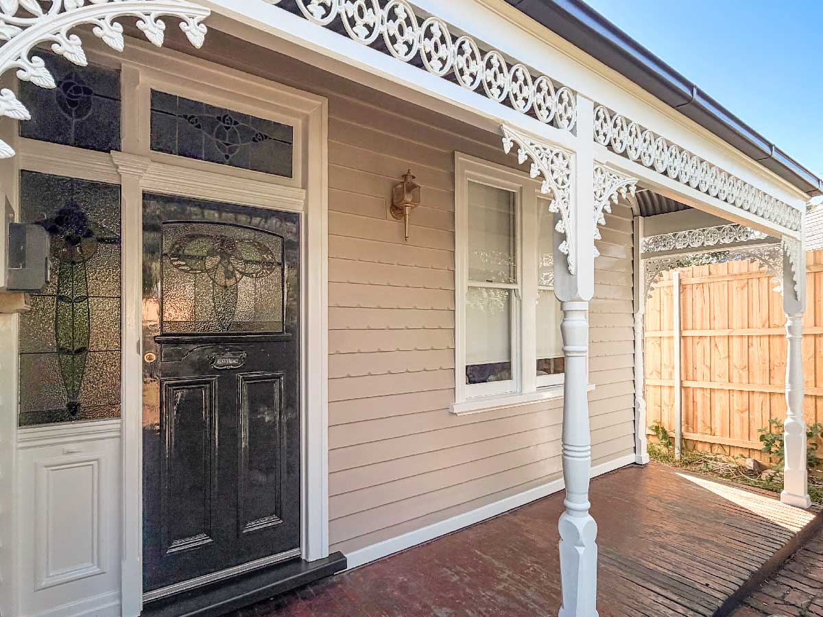 Repainted Federation weatherboard verandah with leadlight door, turned posts and timber fretwork
